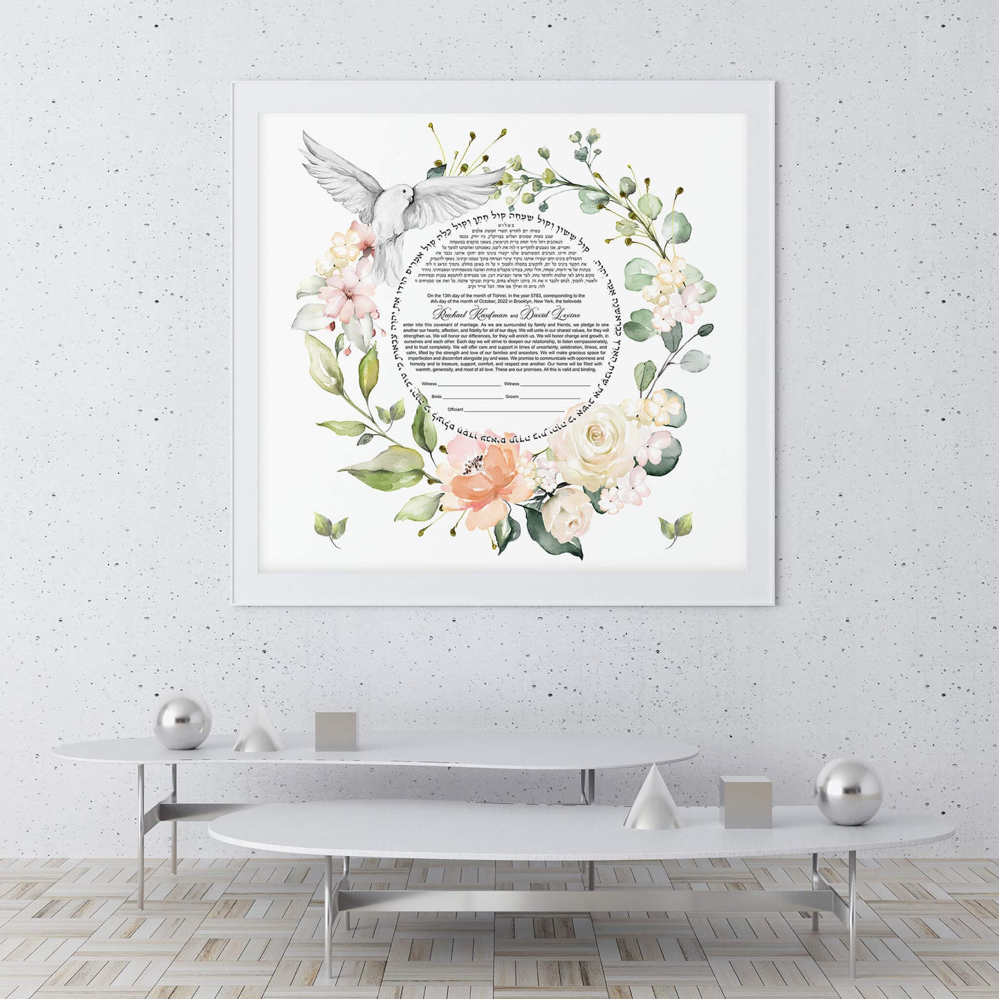 Watercolor floral ketubah displayed on a gray wall in a modern living room.
