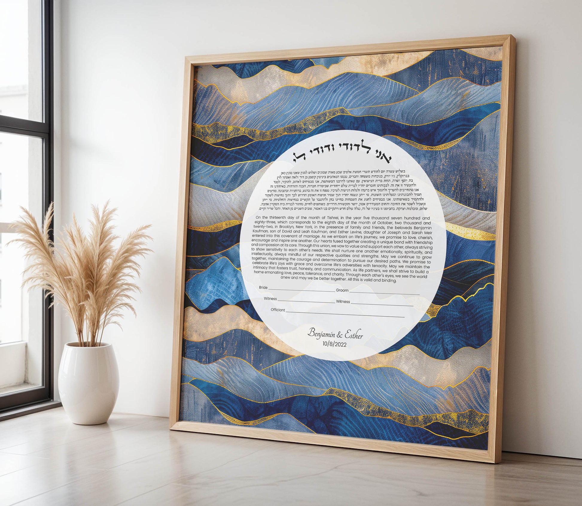 Framed ketubah with blue and gold abstract design on a white wall