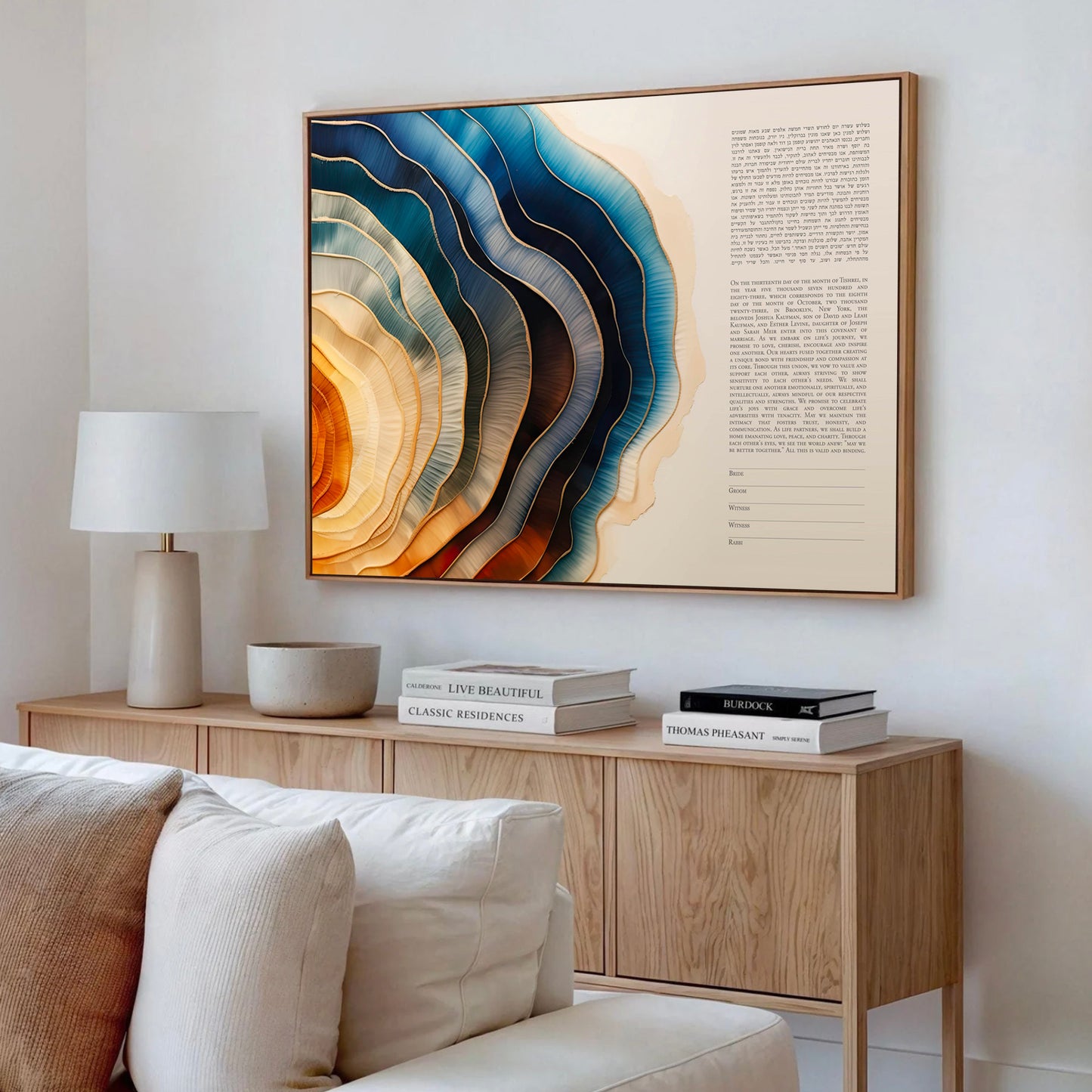 Modern ketubah in a living room with a wooden sideboard, lamp, and abstract wall art.